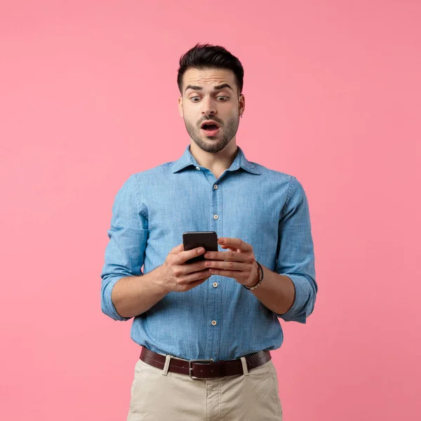 Surprised Casual Guy Holding Phone Reading News Standing Pink Background — Stock Photo, Image