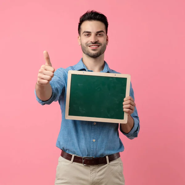 Young Casual Guy Making Thumbs Sign Holding Blackboard Standing Pink — Stock Photo, Image