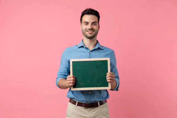 Felice Giovane Ragazzo Sorridente Presentando Lavagna Piedi Sfondo Rosa — Foto Stock