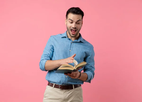 Happy Young Guy Laughing Holding Book Flipping Pages Standing Pink — Stock Photo, Image