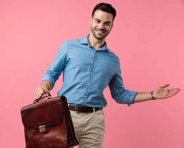 Jong Casual Guy Holding Koffer Presenteren Aan Kant Glimlachen Roze — Stockfoto