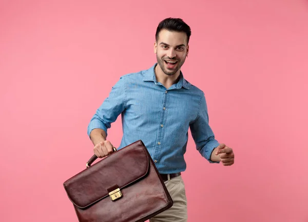 Šťastný Ležérní Chlap Džínové Košili Směje Drží Kufr Chůze Růžovém — Stock fotografie