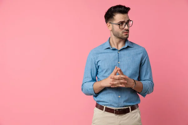 Junger Lässiger Mann Mit Verdächtigem Blick Zur Seite Und Daumendrücken — Stockfoto