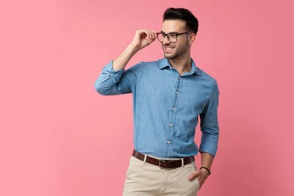 Chico Joven Feliz Camisa Mezclilla Mirando Lado Sonriendo Ajustando Gafas — Foto de Stock