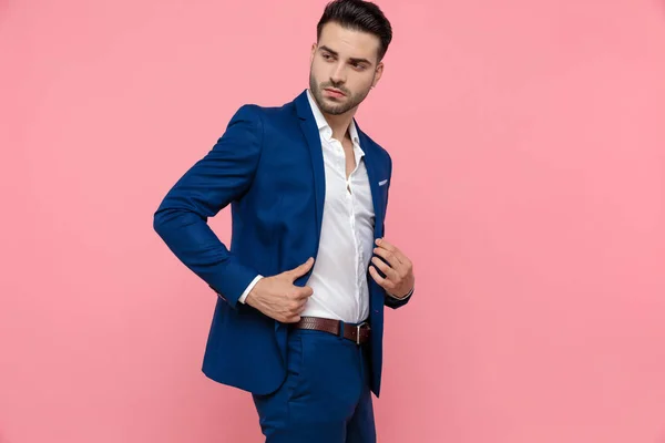 Bonito Homem Negócios Ajustando Seu Casaco Enquanto Vestindo Terno Azul — Fotografia de Stock