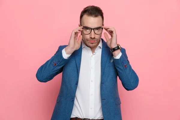 Σοβαρός Έξυπνος Casual Άνθρωπος Προσαρμόζει Γυαλιά Του Και Στέκεται Ροζ — Φωτογραφία Αρχείου