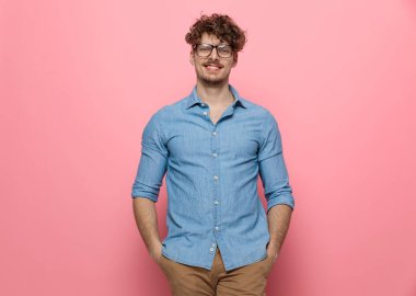 Gülümseyen, el ele tutuşan, pembe arka planda duran mutlu sıradan bir adam.