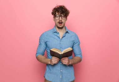 Kitap okuyan ve pembe arka planda duran sıradan genç adamı şok etti.