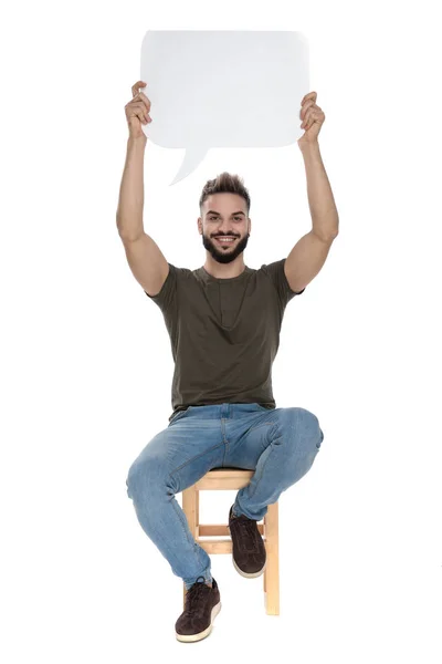 Alegre Hombre Casual Sosteniendo Una Burbuja Habla Blanco Sonriendo Sentado —  Fotos de Stock