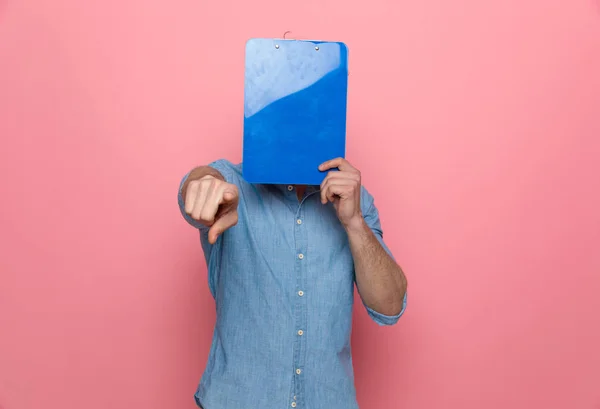 Casual Denim Guy Bedekking Gezicht Met Klembord Wijsvinger Staande Roze — Stockfoto