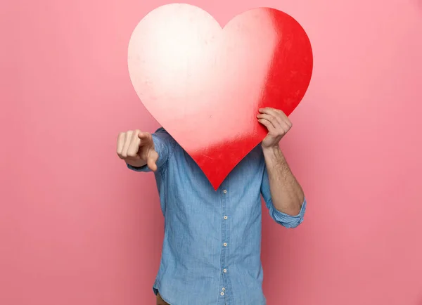 Casual Guy Denim Shirt Hiding Big Red Heart Pointing Finger — Stock Photo, Image