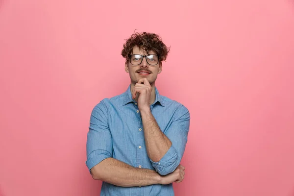 Sorridente Giovane Ragazzo Tenendosi Mano Mento Pensando Piedi Sfondo Rosa — Foto Stock