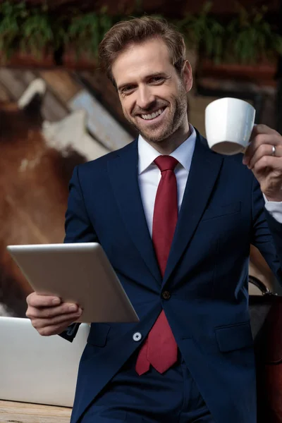 Glimlachende Jonge Zakenman Drinken Van Koffie Holding Tab Een Coffeeshop — Stockfoto