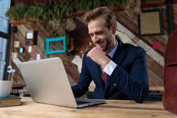 ノートパソコンや笑顔でコーヒーショップに座っている幸せなビジネスマンは — ストック写真