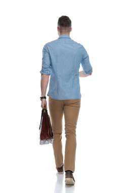 Mavi gömlek giyerken, arka planda beyaz stüdyo arka planında yürürken,