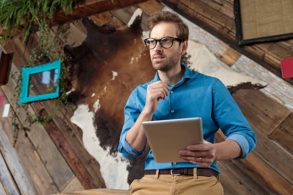 Wondering Model Holding Pad Looking Away While Wearing Blue Shirt — Stock Photo, Image