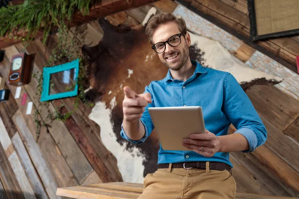 Cheerful Model Holding Tablet Pointing While Wearing Blue Shirt Glasses — Stock Photo, Image