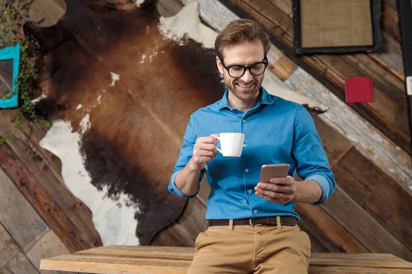 Glad Modell Skrattar Håller Kaffekopp Och Telefon Samtidigt Bär Blå — Stockfoto