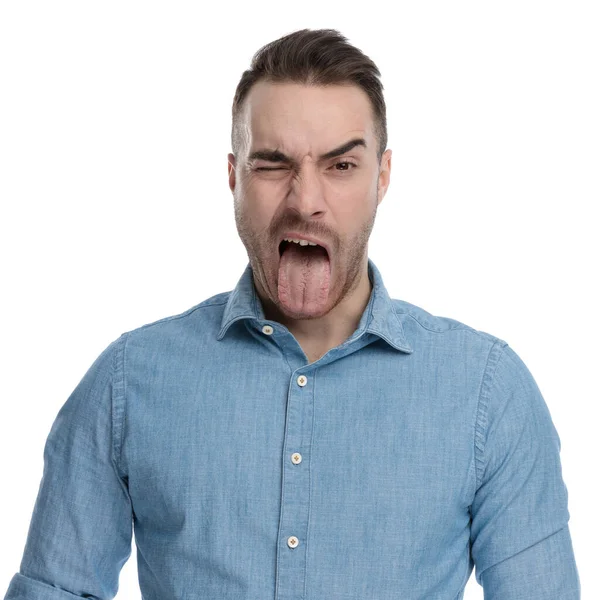 Engraçado Homem Casual Piscando Furando Língua Enquanto Vestindo Camisa Azul — Fotografia de Stock