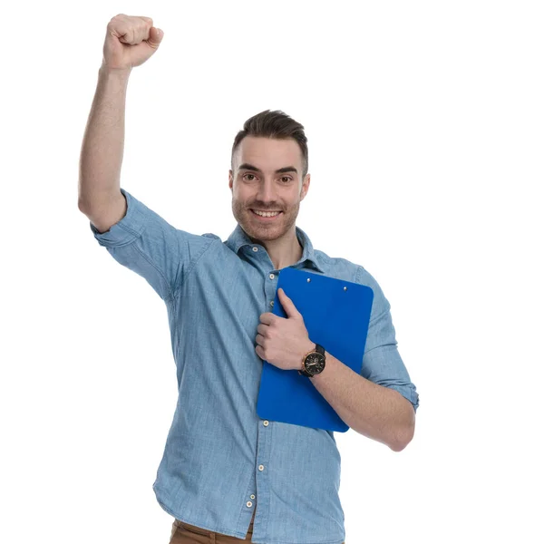 Happy Casual Man Holding Clipboard Celebrating While Wearing Blue Shirt — Stock Photo, Image