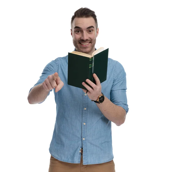 Happy Casual Holding Book Pointing Laughing While Wearing Blue Shirt — Stock Photo, Image