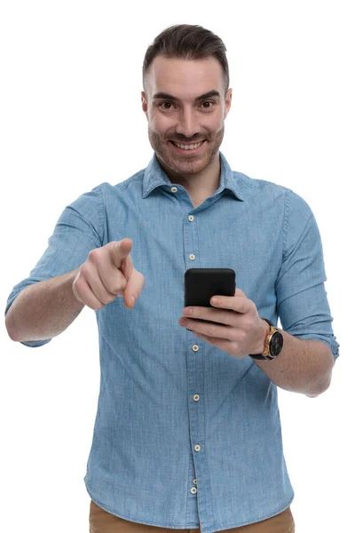 Happy Casual Άνθρωπος Κρατώντας Τηλέφωνο Χαμογελώντας Και Δείχνοντας Φορώντας Μπλε — Φωτογραφία Αρχείου