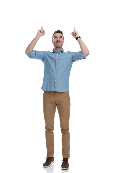 Feliz Hombre Casual Apuntando Hacia Arriba Con Ambas Manos Mientras —  Fotos de Stock