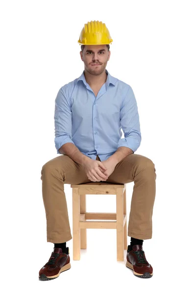 Bothered Casual Man Frowning Wearing Hard Hat While Sitting Chair — Stock Photo, Image