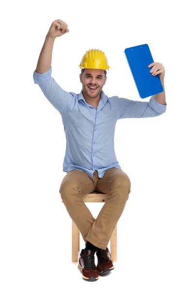 Homem Casual Feliz Vestindo Chapéu Duro Celebrando Com Prancheta Mão — Fotografia de Stock