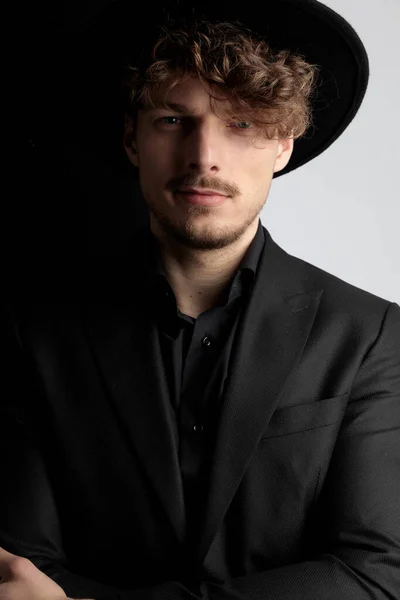 スーツと帽子を身に着けている間 前向きなファッションモデルは前方と笑顔 黒と白のスタジオの背景に立って — ストック写真