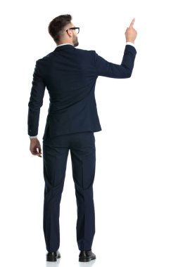 Gözlüklü genç bir işadamının dikiz aynasından beyaz stüdyo arkaplanını gösteriyor.