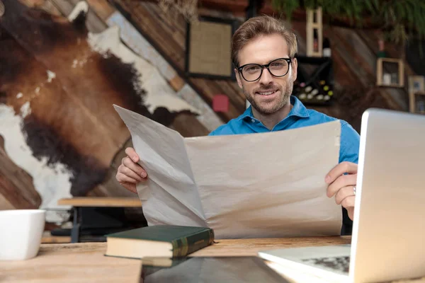 Casual Άνθρωπος Φορώντας Γυαλιά Κάθεται Στο Γραφείο Και Διαβάζοντας Την — Φωτογραφία Αρχείου