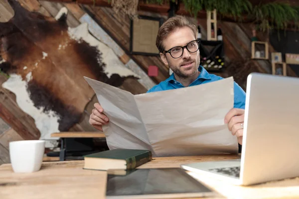 Casual Man Wearing Glasses Sitting Desk Reading Newspaper While Looking — Stock Photo, Image