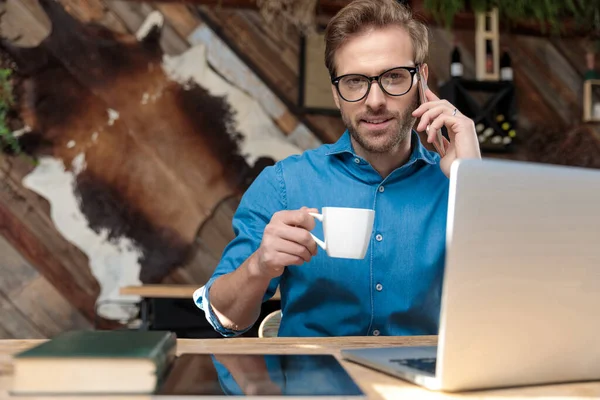 Επιχειρηματίας Φορώντας Γυαλιά Κάθεται Στο Γραφείο Και Πίνοντας Καφέ Ενώ — Φωτογραφία Αρχείου