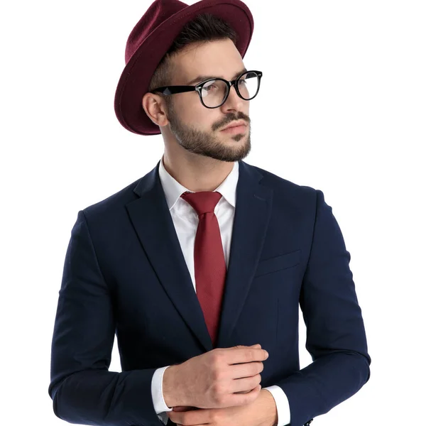 魅力的なビジネスマンは 白いスタジオの背景にクールな態度でポーズを取りながら バーガンディ帽子立って袖を固定を身に着けて — ストック写真