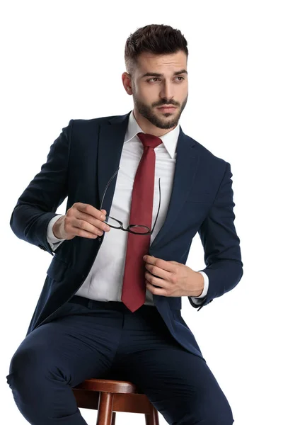 Empresário Sexy Vestindo Terno Marinha Sentado Enquanto Tira Seus Óculos — Fotografia de Stock