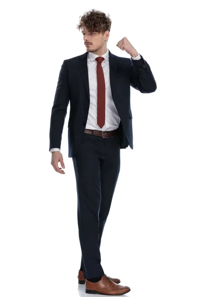 スーツを着て白いスタジオの背景に立っている間 彼の拳で肩と警告を見て怒っているビジネスマンの側面図 — ストック写真