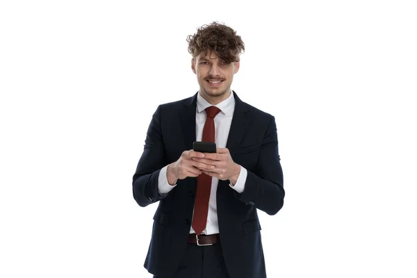 Feliz Hombre Negocios Sosteniendo Teléfono Sonriendo Mientras Usa Traje Pie —  Fotos de Stock