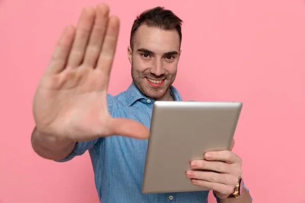 Sexy Casual Mężczyzna Robi Znak Stopu Trzymając Jego Tablet Uśmiechając — Zdjęcie stockowe