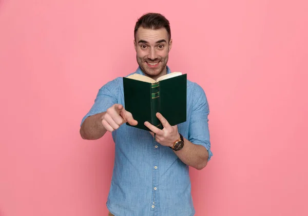 Stilig Avslappnad Man Pekar Framåt Håller Sin Bok Och Ler — Stockfoto