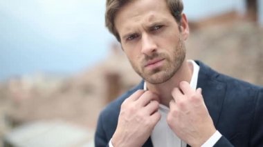 Donanma kıyafeti giyen bir işadamının yakasını düzeltip dışarı bakıyor.