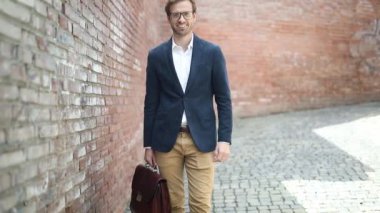 Çekici, heyecanlı iş adamı yumruğunu kaldırıyor, gözlük takıyor, evrak çantası tutuyor ve gülümsüyor.