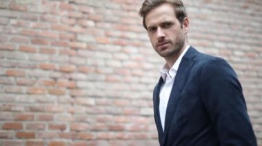 Zeki, sıradan bir iş adamının duvarın yanında dikilip poz verirken gülümseyen, donanma kıyafeti giyen...