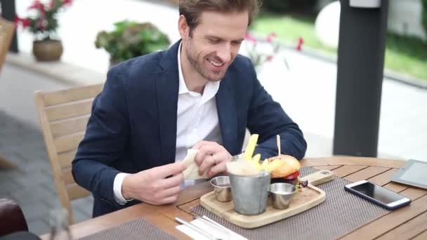 Szőke Fiatal Üzletember Tengerész Öltönyben Asztalnál Sült Krumplit Eszik Teraszon — Stock videók