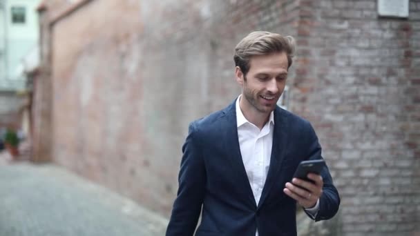 Jovem Empresário Atraente Andando Mensagens Texto Seu Telefone Falando Telefone — Vídeo de Stock