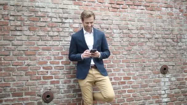 Young Blond Businessman Leaning Brick Wall Texting His Phone Giving — Stock Video