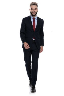 Mutlu genç iş adamı beyaz arka planda gülümsüyor ve yürüyor