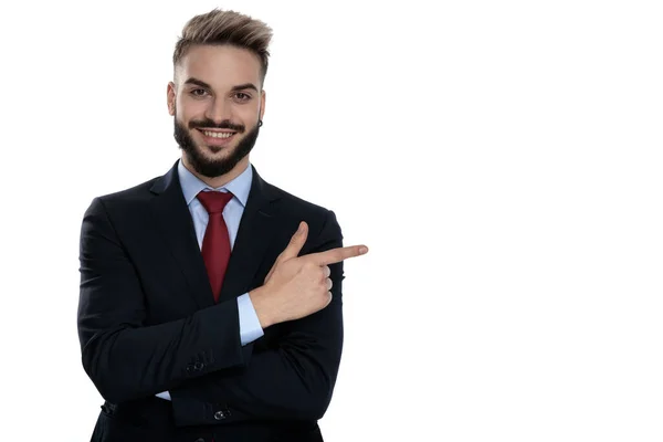 Щасливий Молодий Бізнесмен Вказуючи Пальцем Бік Посміхаючись Стоїть Ізольовано Білому — стокове фото