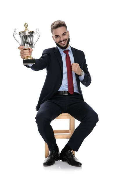 Happy Young Businessman Holding Presenting Trophy Smiling Sitting Isolated White — Stock Photo, Image