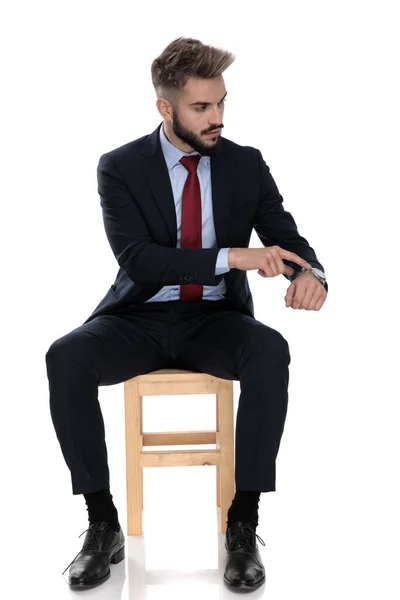 性感的年轻生意人侧身而坐 孤零零地坐在白色的背景上 — 图库照片